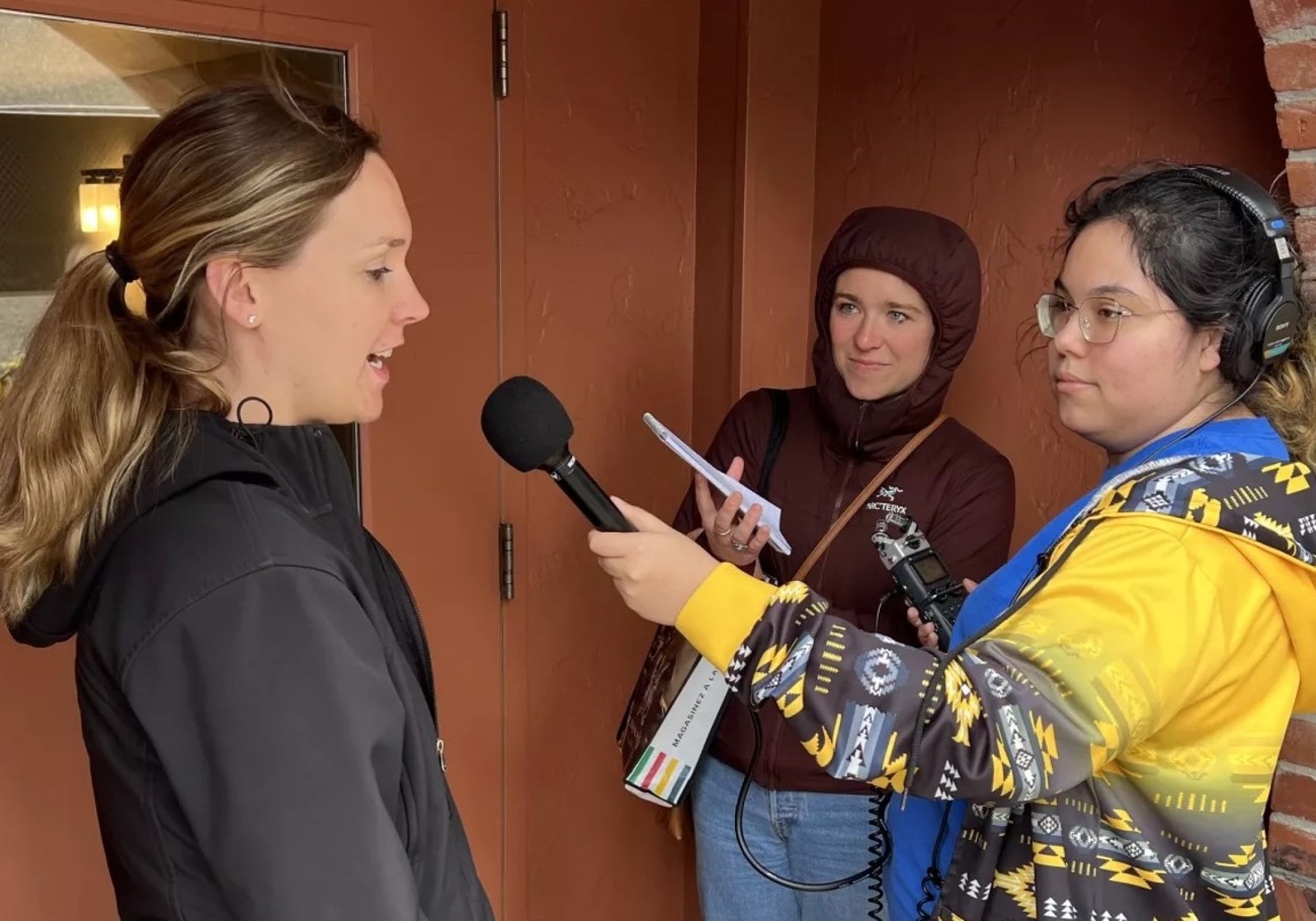 Journalism students interviewing a woman on assignment